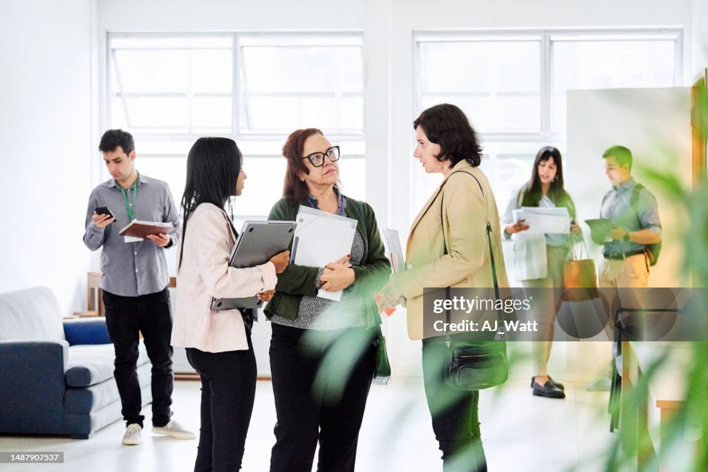 Business people discussing in office lobby after a conference event