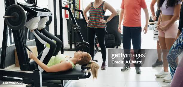 gym coach showing class how to using exercise machine - hamstring machine stock pictures, royalty-free photos & images