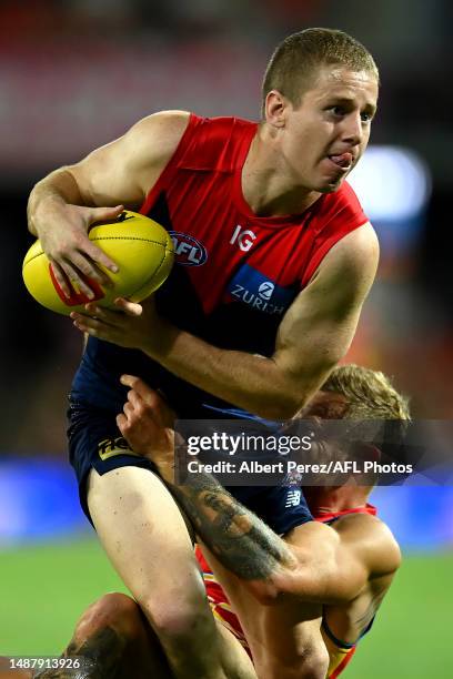 Lachie Hunter of the Demons is tackled by Brandon Ellis of the Suns during the round eight AFL match between the Gold Coast Suns and the Melbourne...