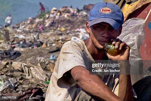 Nicaraguan boy, a garbage recollector, sniffs glue in the garbage dump La Chureca, on 9 November, 2004 in Managua, Nicaragua. La Chureca is the...