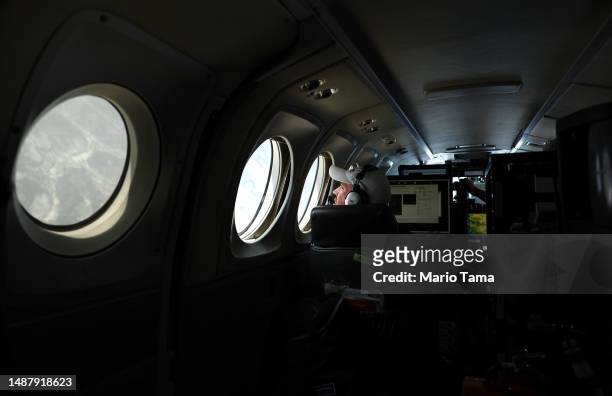 SnowEx campaign researcher Niklas Bohn, postdoctoral fellow, works aboard a campaign plane which is studying changes in snow albedo in the Interior...