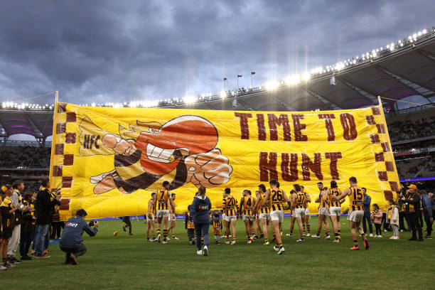The Hawks prepare to run thru their banner during the round eight AFL match between Fremantle Dockers and Hawthorn Hawks at Optus Stadium, on May 06...