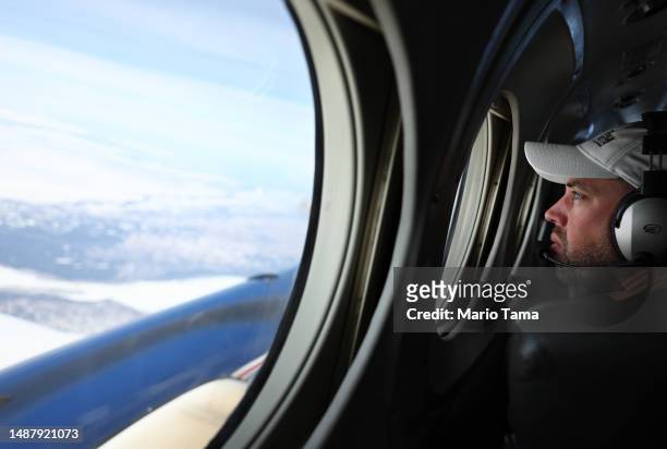SnowEx campaign researcher Niklas Bohn, postdoctoral fellow, works aboard a campaign plane which is studying changes in snow albedo in the Interior...