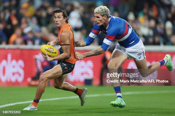 Isaac Cumming of the Giants is tackled by Rory Lobb of the Bulldogs during the round eight AFL match between Greater Western Sydney Giants and...