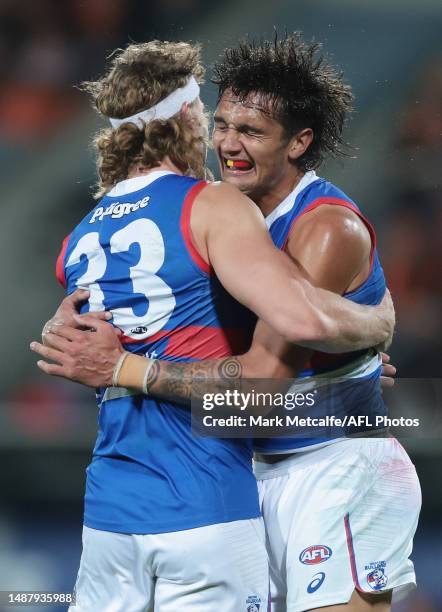 Aaron Naughton of the Bulldogs celebrates kicking a goal with team mate Jamarra Ugle-Hagan of the Bulldogs during the round eight AFL match between...