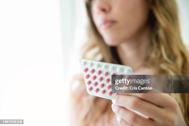 woman holding contraceptive pill - hrt pill stockfoto's en -beelden