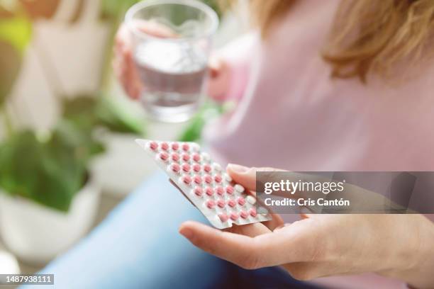 woman holding contraceptive pill - pilule contraceptive photos et images de collection