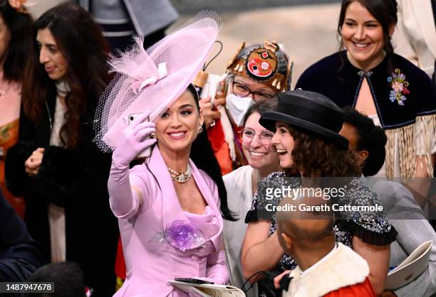 Katy Perry takes selfies with guests during the Coronation of King Charles III and Queen Camilla on May 06, 2023 in London, England. The Coronation...