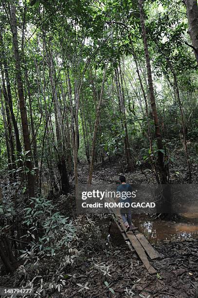 To go with AFP story Indonesia-France-environment-animal,FEATURE by Loic Vennin This photograph taken on June 7, 2012 shows a man crossing a...