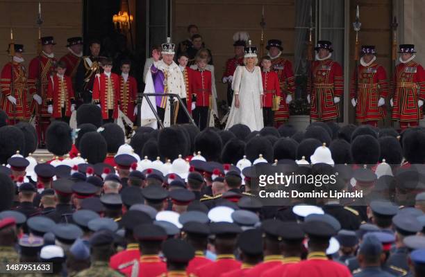 King Charles III and Queen Camilla receive the royal salute from gathered military personnel on the West Terrace of the Buckingham Palace gardens...