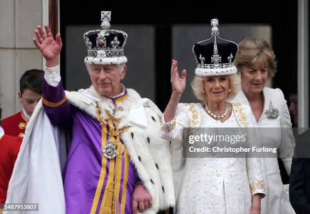 King Charles III and Queen Camilla can be seen on the Buckingham Palace balcony ahead of the flypast during the Coronation of King Charles III and...