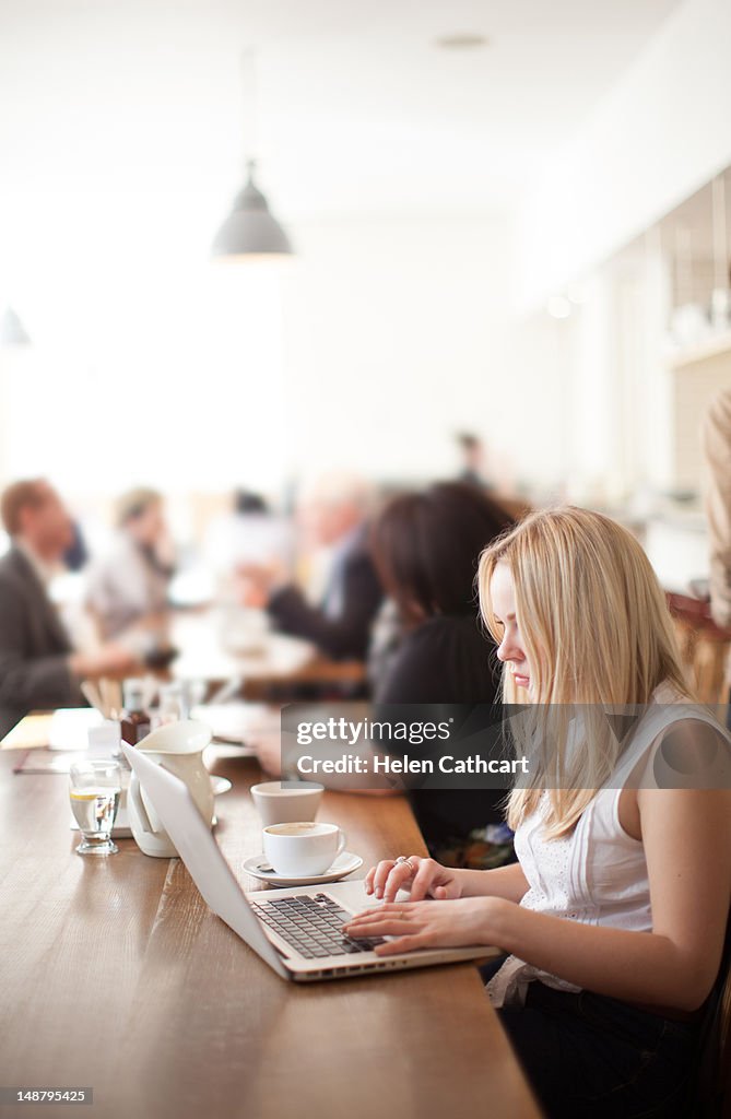 Woman in cafe working on laptop