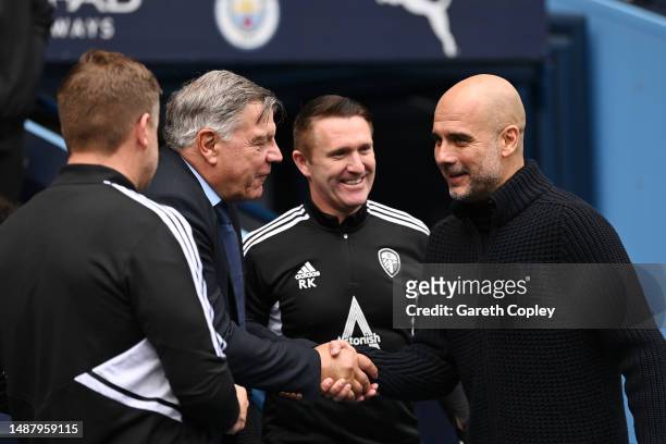 Sam Allardyce, Manager of Leeds United, interacts with Pep Guardiola, Manager of Manchester City, prior to the Premier League match between...