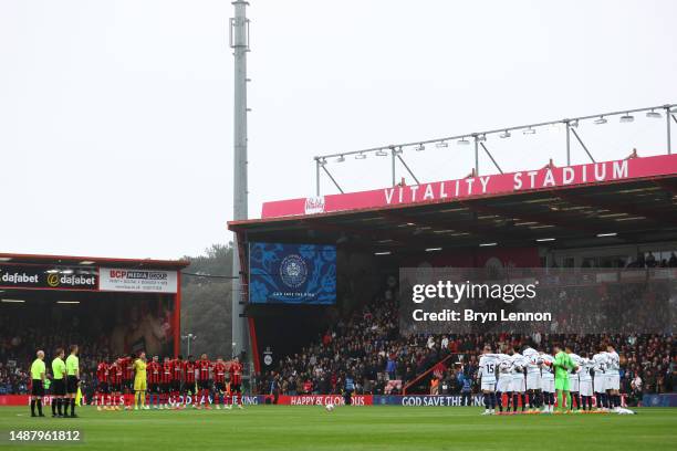 Players, fans and officials stand for the national anthem for the Coronation of Charles III and Camilla prior to the Premier League match between...