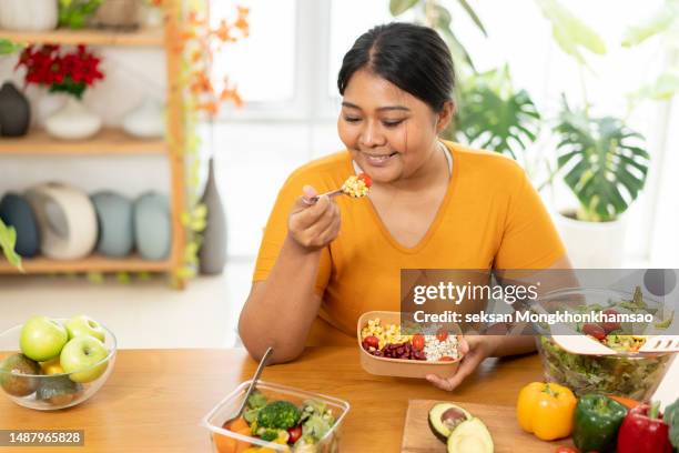 plus size woman eating salad. - eating fiber stock pictures, royalty-free photos & images