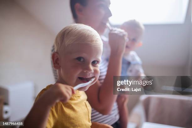 portrait of a cheerful boy brushing his teeth - brushing teeth stock pictures, royalty-free photos & images