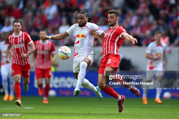 Christopher Nkunku of RB Leipzig is challenged by Manuel Gulde of Sport-Club Freiburg during the Bundesliga match between Sport-Club Freiburg and RB...