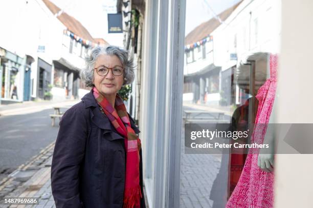 frau steht vor einem schaufenster in einer alten englischen stadt - schaufenster stock-fotos und bilder