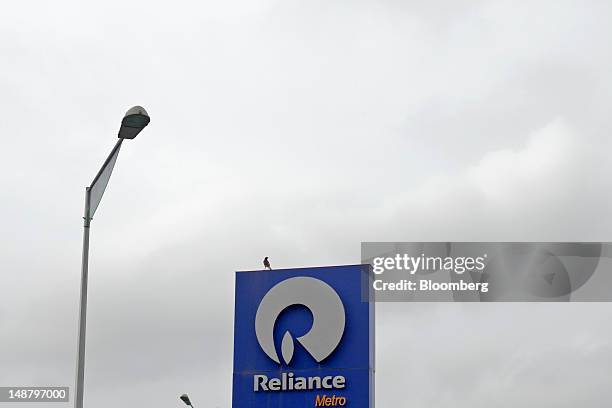 The Reliance Industries Ltd. Logo is displayed at the company's gas station in Mumbai, India, on Thursday, July 19, 2012. Reliance Industries Ltd. Is...