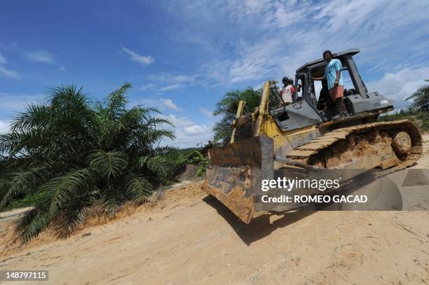 Indonesia-France-environment-animal,FEATURE by Loic Vennin This photograph taken on June 5, 2012 shows workers driving a bulldozer near a newly...