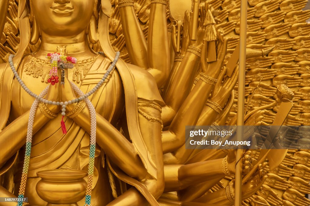 Cropped shot of Guanyin of the Thousand Hands statue situated in traditional Chinese temple.