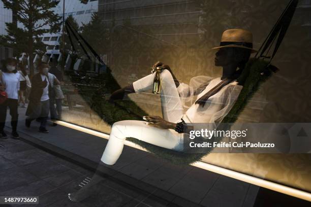 mannequin laying down in a store window - shoppers view holiday windows ahead of consumer comfort figures stock pictures, royalty-free photos & images