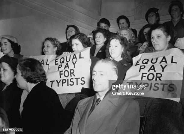 Five typists , with 'Equal Pay For Typists' placards, listen to the speeches during an 'Equal Pay for Women' campaign meeting, held at Central Hall...