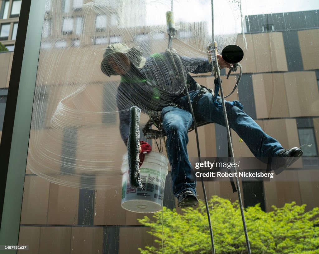 Window Cleaner Trade A commercial window cleaner hangs from a harness as he cleans... News ...