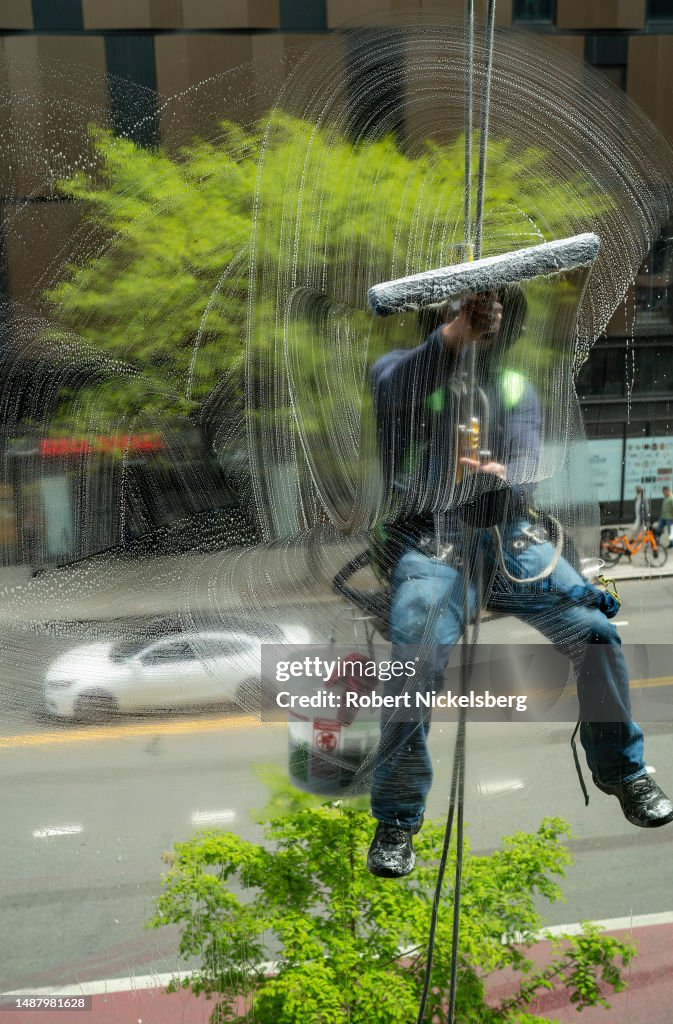 Window Cleaner Trade A commercial window cleaner hangs from a harness as he cleans... News ...