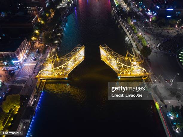 suspension bridge open up to let large boat go through at night - bridge gap stockfoto's en -beelden