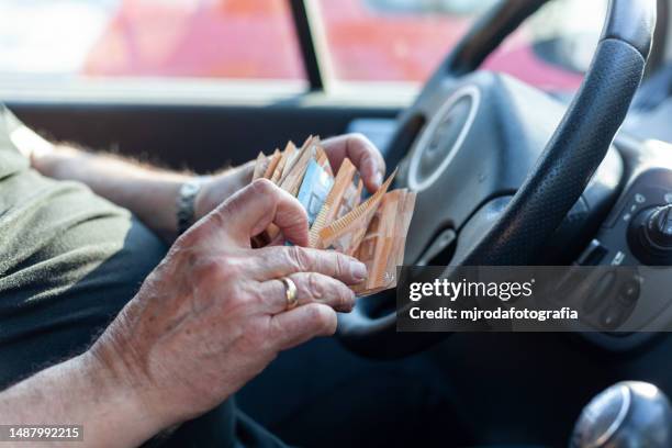 closeup of the hands of a man counting euro banknotes - euro symbol stock pictures, royalty-free photos & images
