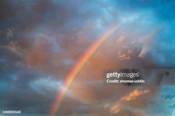 sky with rainbow at sunset - regenboog stockfoto's en -beelden