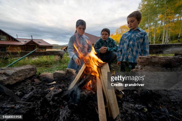 brothers enjoy a campfire on a farm ranch in telluride, colorado, creating cherished memories amidst the serene beauty of the countryside - san miguel range stockfoto's en -beelden