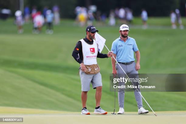 Cameron Young of the United States talks with his caddie Paul Tesori on the 14th hole during the third round of the Wells Fargo Championship at Quail...