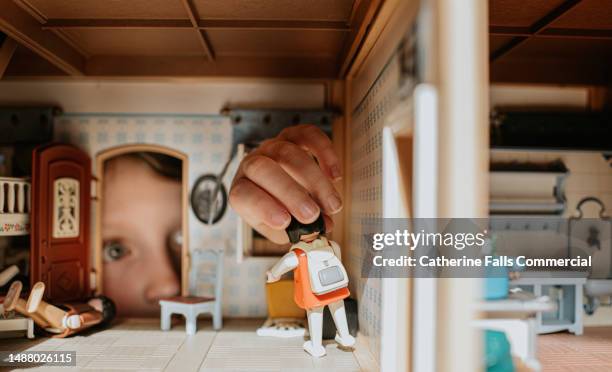 a little girl peering through the door of a dolls house - emotional intelligence stock pictures, royalty-free photos & images