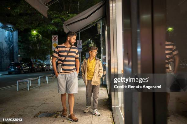 padre e hijo comprando en la calle por la noche - padre soltero fotografías e imágenes de stock