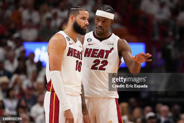 Jimmy Butler of the Miami Heat talks with Caleb Martin during game three of the Eastern Conference Semifinals at Kaseya Center on May 06, 2023 in...