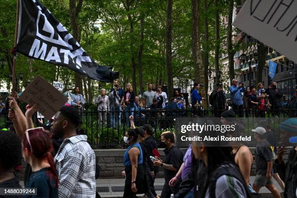 People in Bryant Park watch as protesters march from the Broadway-Lafayette subway station to the Lexington Ave/63rd Street subway station during a...