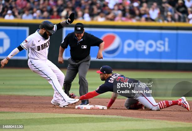 Emmanuel Rivera of the Arizona Diamondbacks is safe at second base ahead of the tag by Luis Garcia of the Washington Nationals during the third...
