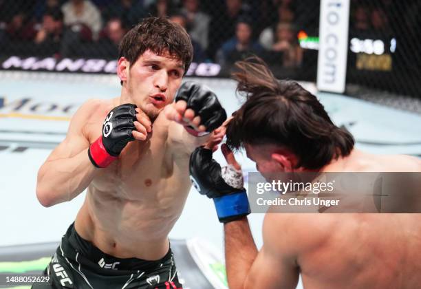 Movsar Evloev of Russia punches Diego Lopes of Brazil in a featherweight fight during the UFC 288 event at Prudential Center on May 06, 2023 in...