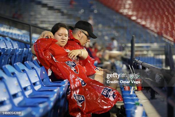 Dallas fans take cover from the rain while waiting to resume the MLS game between the St. Louis City SC and the FC Dallas that has been temporarily...