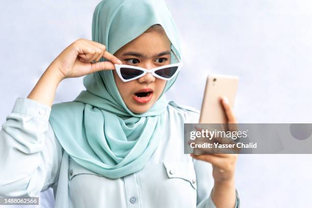 a girl looking at her phone and shocked - veil face stock pictures, royalty-free photos & images