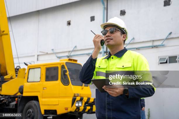 engineers lifting loads with a large lifting crane - mobile crane stock pictures, royalty-free photos & images