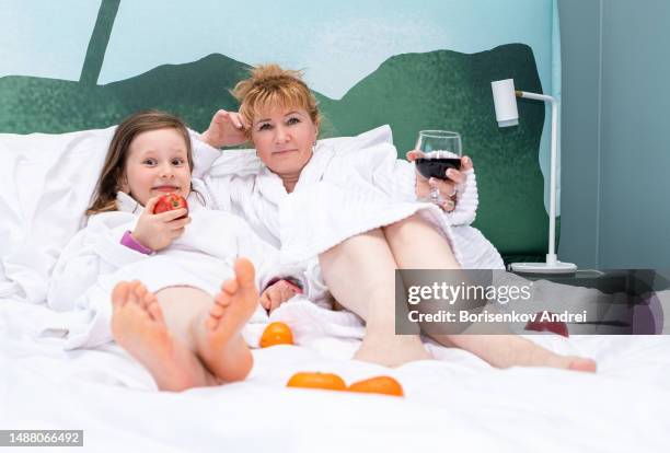 caucasian woman 40 years old, together with her daughter a child of 7 years old. the family spends time together on vacation. the woman drinks red wine and the child eats fruit. - lebanon wine stock pictures, royalty-free photos & images