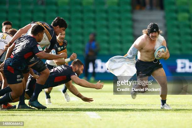 Lachlan Lonergan of the Brumbies loses his jersey as he runs with the ball during the round 11 Super Rugby Pacific match between Melbourne Rebels and...