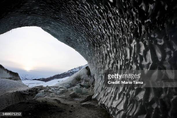 Fallen ice chunks rest in an ice cave created by meltwater at the retreating Castner Glacier in the Alaska Range on May 5, 2023 near Paxson, Alaska....