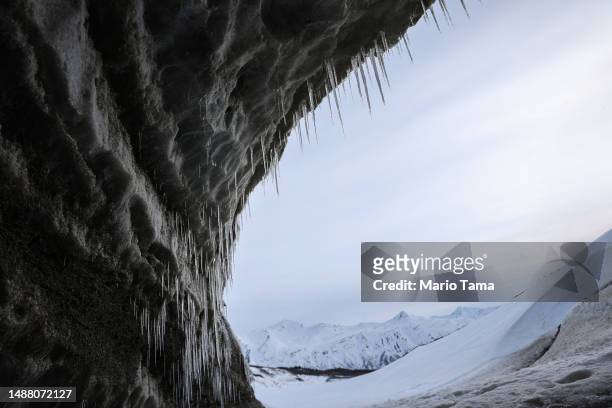 Icicles hang in an ice cave created by meltwater at the retreating Castner Glacier in the Alaska Range on May 5, 2023 near Paxson, Alaska. The ice...