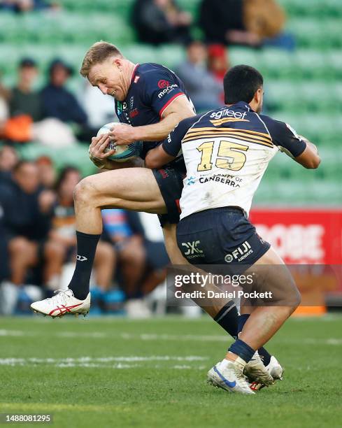 Reece Hodge of the Rebels is tackled by Tom Wright of the Brumbies during the round 11 Super Rugby Pacific match between Melbourne Rebels and ACT...