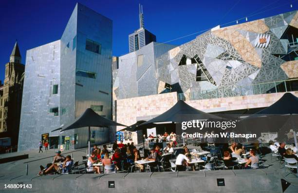 people sitting at outdoor tables, federation square. - federation square fotografías e imágenes de stock