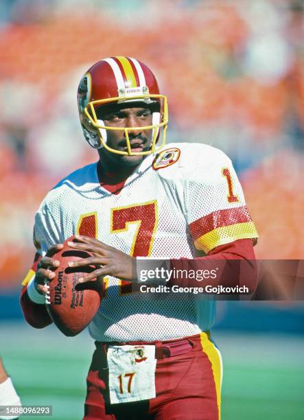 Quarterback Doug Williams of the Washington Redskins warms up on the sideline prior to a National Football League game at RFK Stadium in 1986 in...